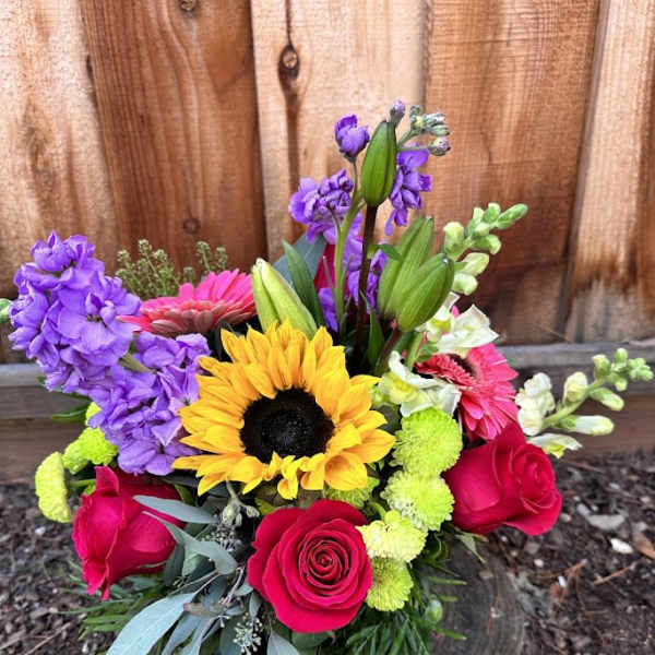Colorful bouquet with sunflowers, roses, and purple blooms