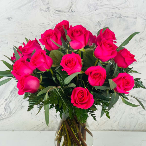 Hot pink roses arranged in a clear glass vase