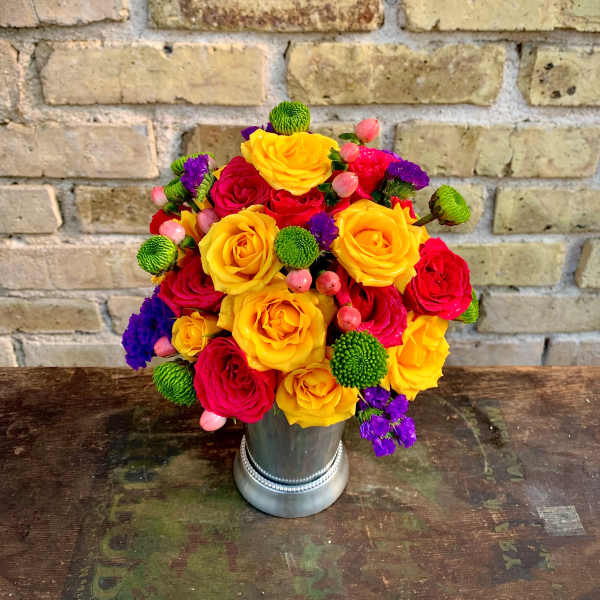 Bright bouquet of yellow and red roses in a silver vase