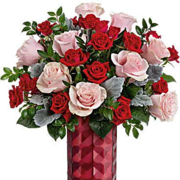 Red and pale pink roses arranged in a tall red vase