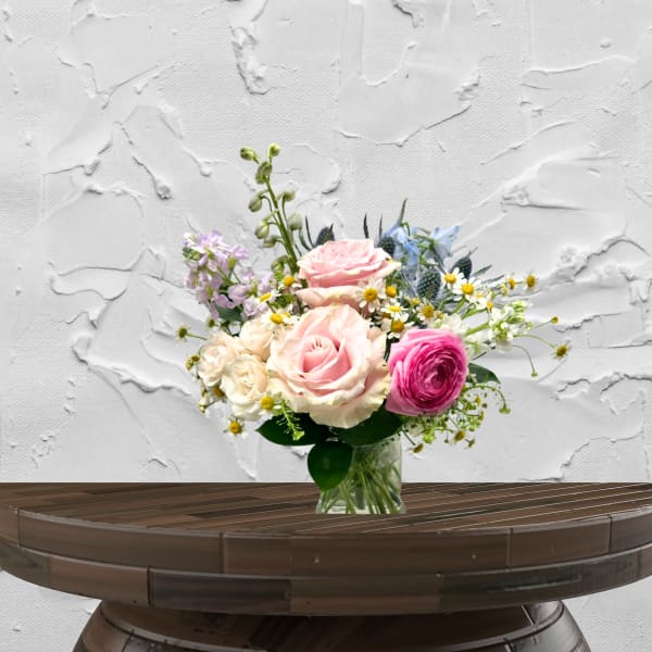 Mixed bouquet of pink and cream roses in a clear glass vase