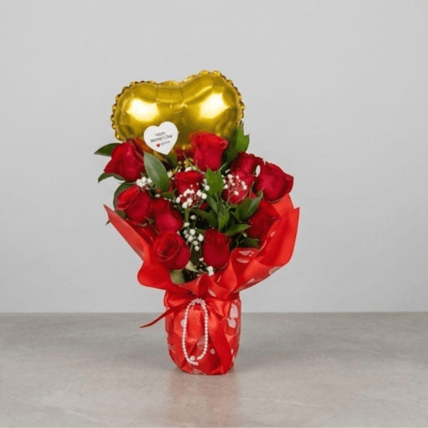 Glass vase wrapped in red paper, natural roses, heart-shaped balloon with a message for Mother's Day