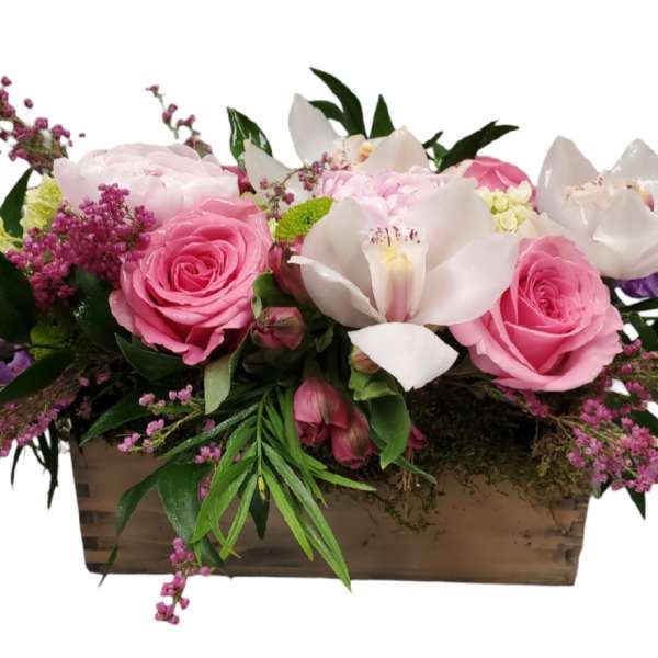 Pink roses and white orchids arranged in a wooden box