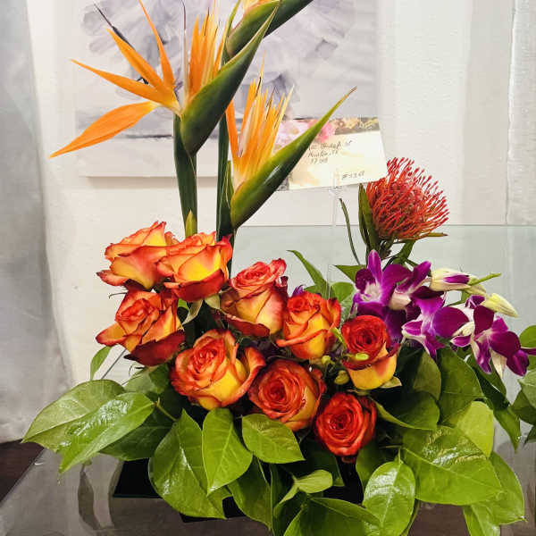 Tropical bouquet with orange bird-of-paradise, roses, and purple orchids