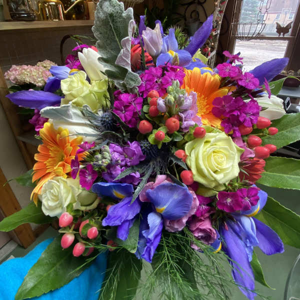 Colorful mixed bouquet with roses, gerbera daisies, and purple irises
