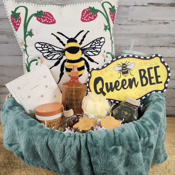 Bee-themed gift basket with a decorative pillow and assorted treats