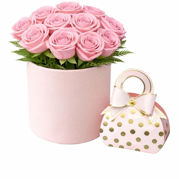 Pink rose arrangement in a round box with a polka-dot gift bag