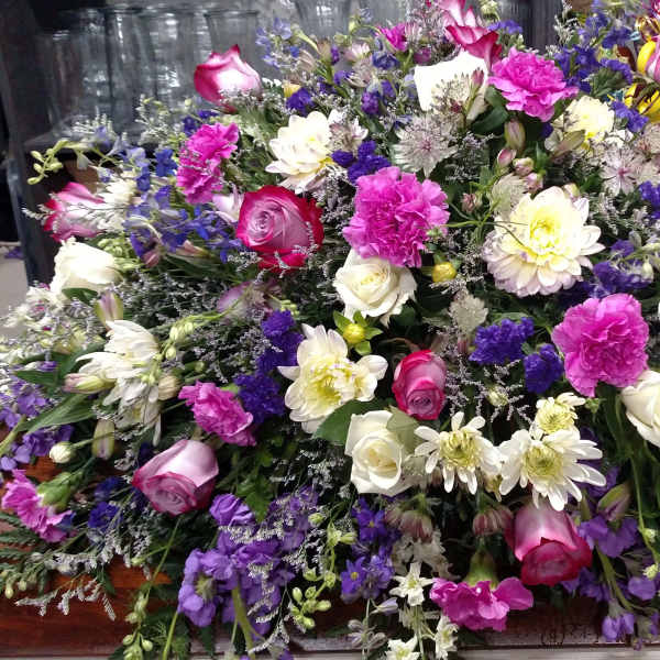 Large casket spray with pink, white, and purple flowers