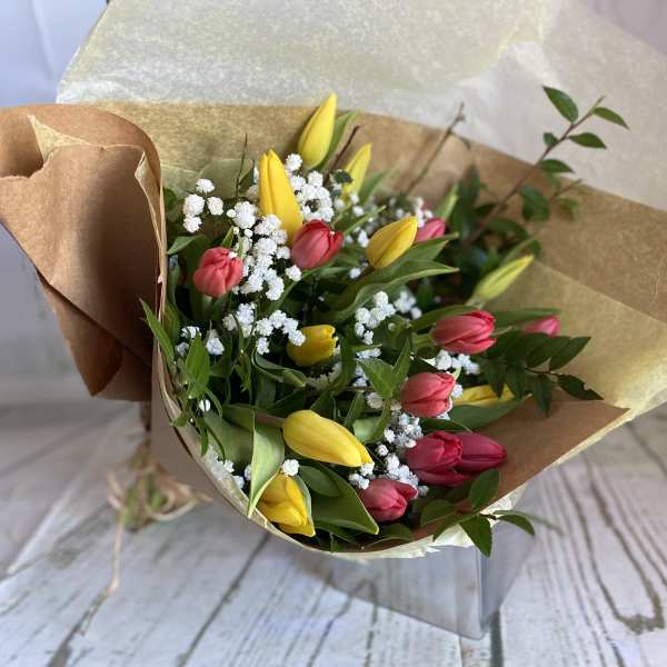 Bouquet of yellow and pink tulips with white filler flowers