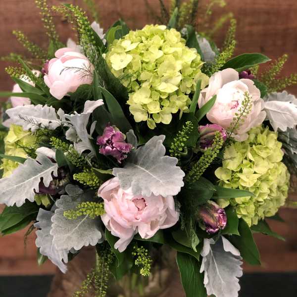 Bouquet of pale pink peonies and lime hydrangeas with silver foliage