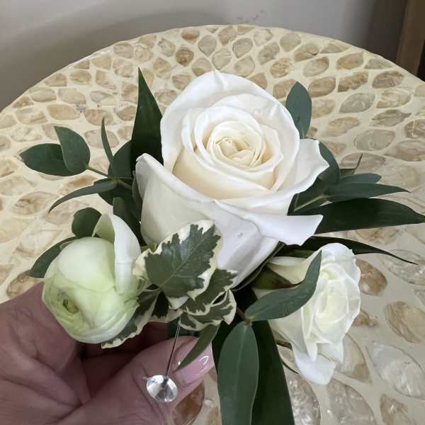 White rose bouquet with green foliage and a small white bud