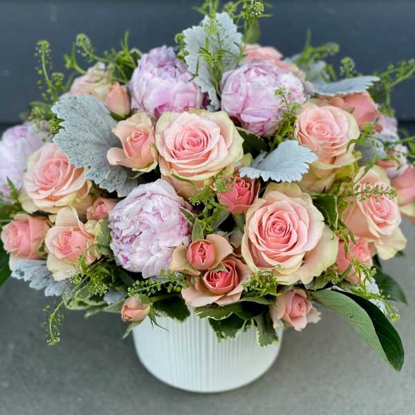Pink roses and peonies arranged in a white vase