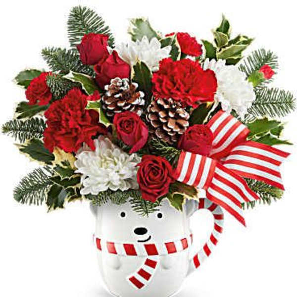Red and white floral arrangement in a white bear-shaped container with striped ribbon