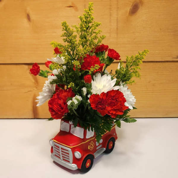 Red and white carnations in a red toy truck container