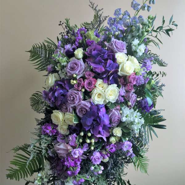 Large purple and white floral standing spray on an easel