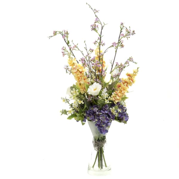 Tall bouquet of purple and yellow flowers in a clear glass vase