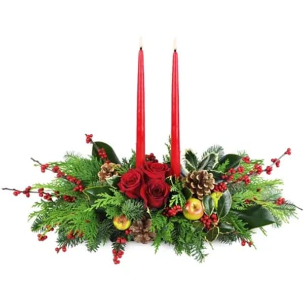 Red roses and candles in a holiday centerpiece with pinecones and berries