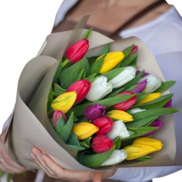 Bouquet of multicolored tulips wrapped in beige paper