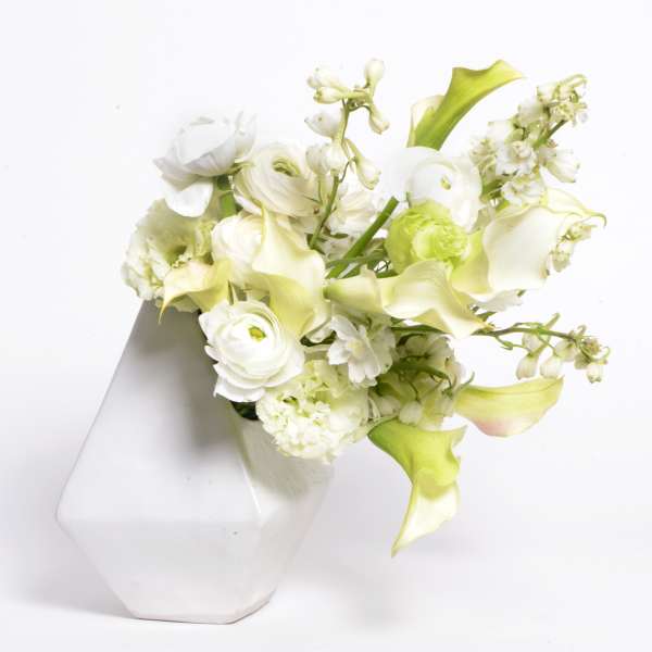 White and pale green floral arrangement in a white vase
