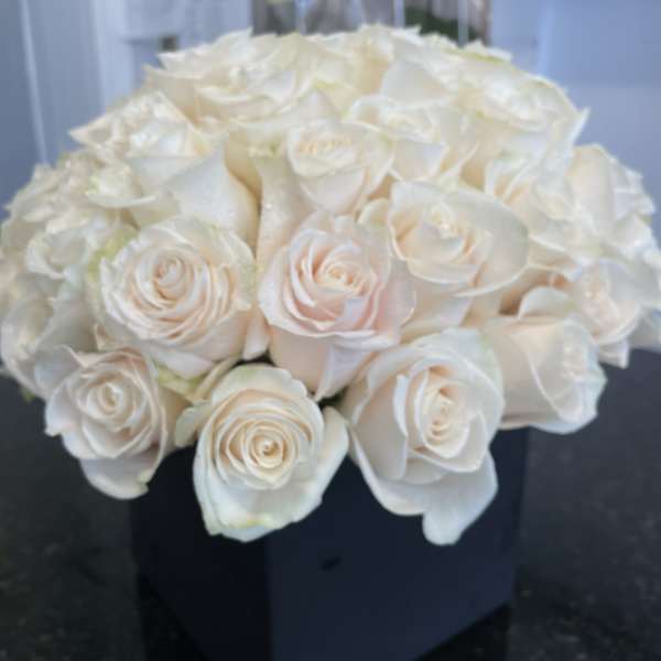 Bouquet of white roses in a dark box