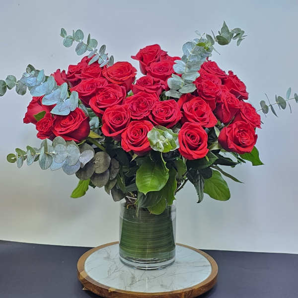 Bouquet of red roses in a glass vase with eucalyptus