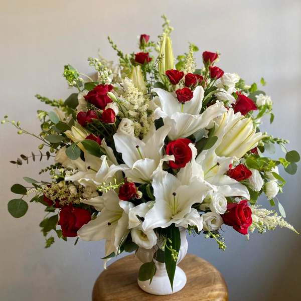 Red roses and white lilies in a white vase