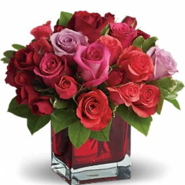 Bouquet of red and pink roses in a red glass vase