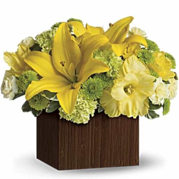 Yellow lilies and white flowers arranged in a square wooden container