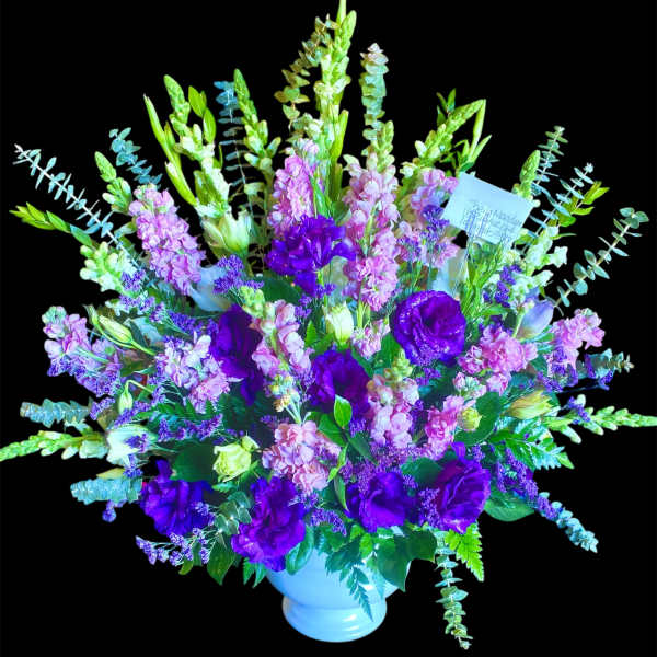 Purple and pink floral arrangement in a white vase