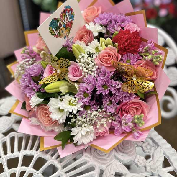 Pink and purple bouquet with roses, daisies, and a LOVE card