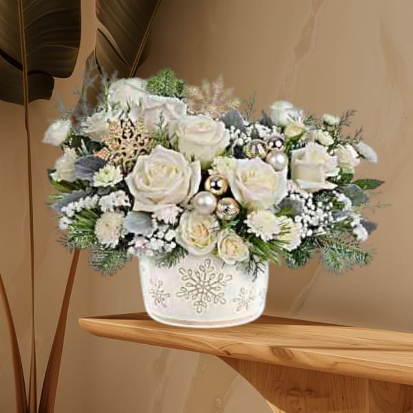 White rose arrangement in a snowflake-decorated vase