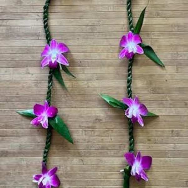 Braided floral garland with purple orchid blossoms on a wood background