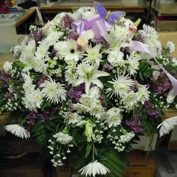Large white floral spray with a lavender ribbon and bow