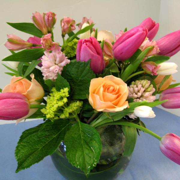 Pink tulips and peach roses in a glass vase