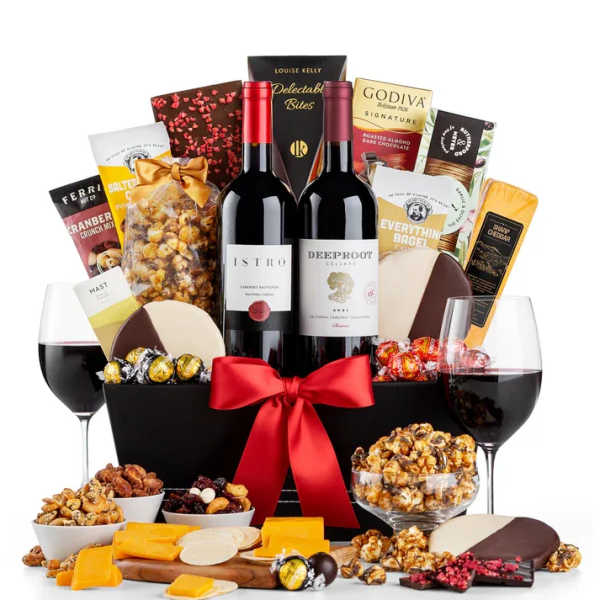 Gift basket with wine, chocolates, snacks, and cheese, tied with a red ribbon
