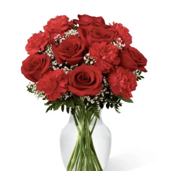 Red roses and carnations in a clear glass vase