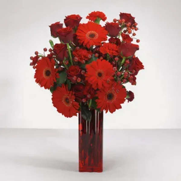 Red gerberas and roses in a tall red vase