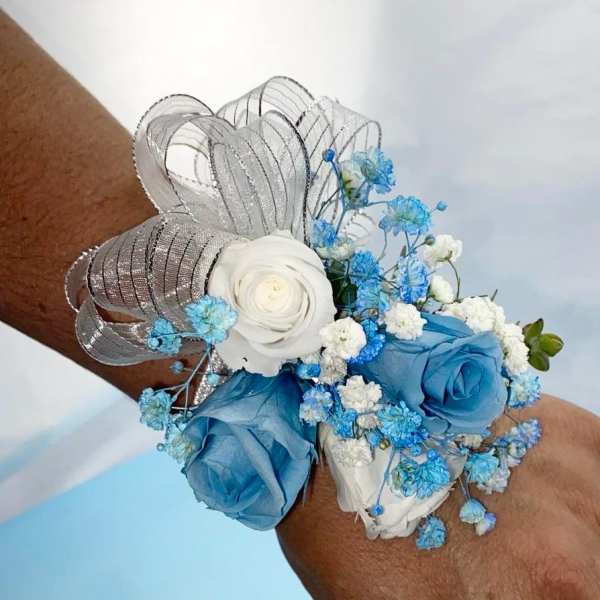 Blue and white wrist corsage with ribbon loops and small flowers