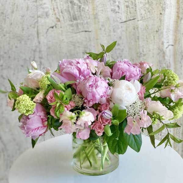 Pink and white mixed flower arrangement in a clear glass vase