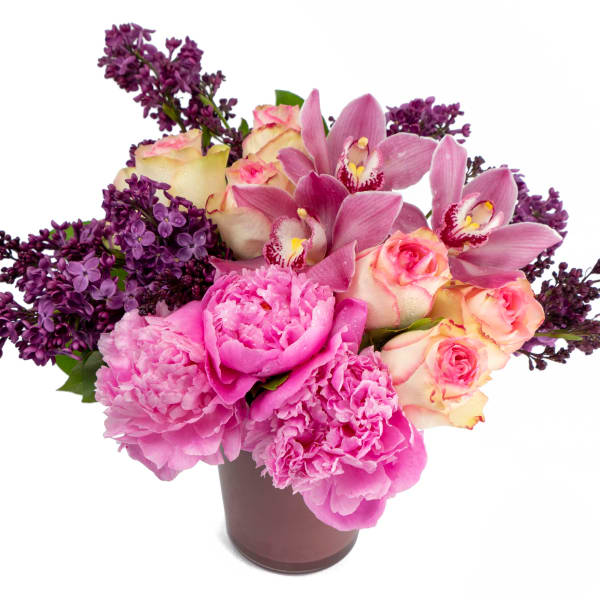 Pink and purple bouquet with roses, peonies, and orchids in a vase