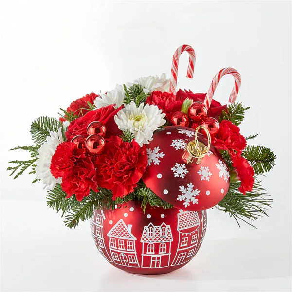 Red and white holiday arrangement in a decorated red ornament vase