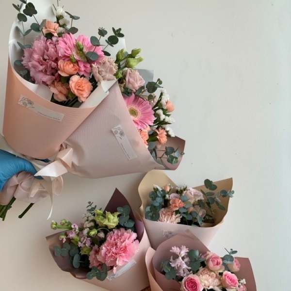 Five pastel flower bouquets wrapped in pink paper