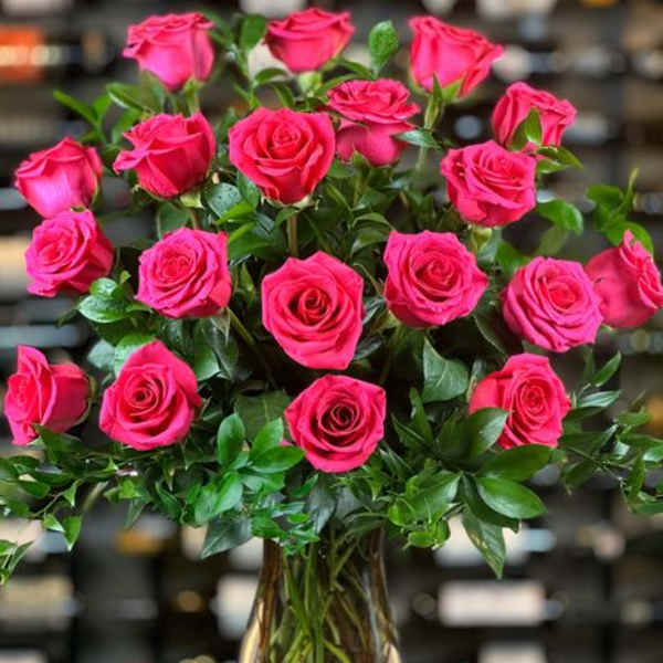 Pink roses arranged in a clear glass vase.