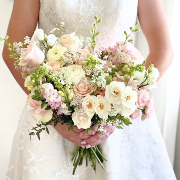 Bride holding a pastel bouquet of pink and white flowers