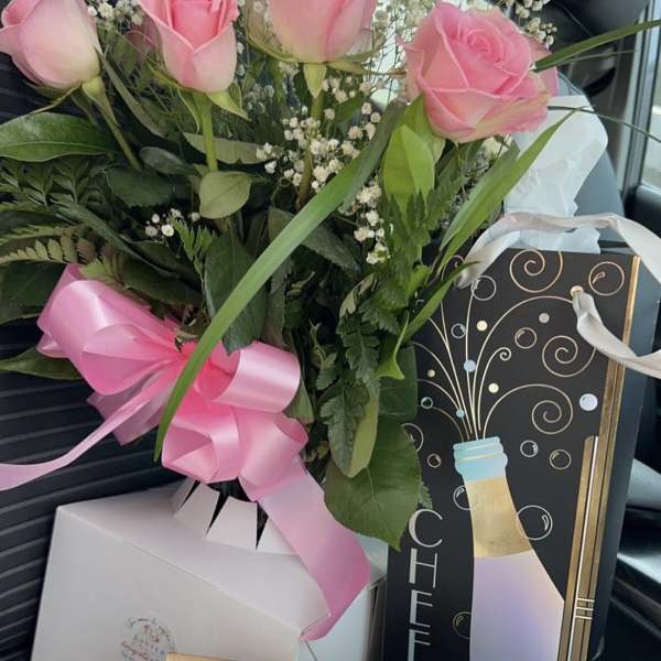 pink roses in a cute glass vase tied with a ribbon by lav.ishbouquets