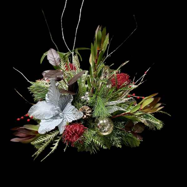 Holiday floral arrangement with red blooms and silver ornaments