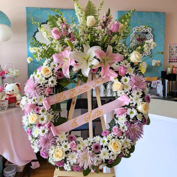 Large floral wreath on an easel with pink and white flowers