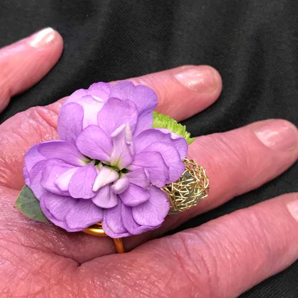 Small purple flower ring on a hand
