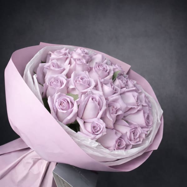 Bouquet of pale lavender roses wrapped in pink paper