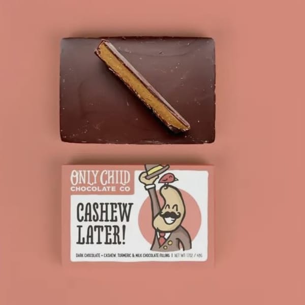 Chocolate bar and its labeled wrapper on a pink background